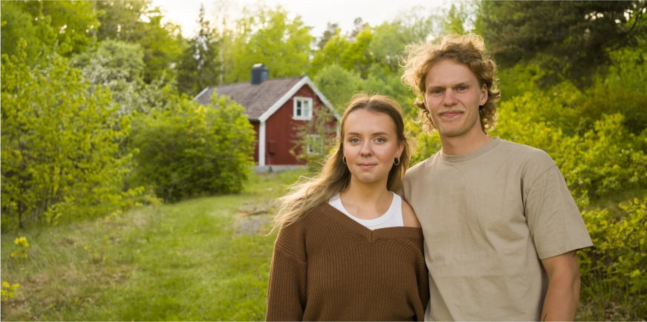 Ett ungt par framför ett hus